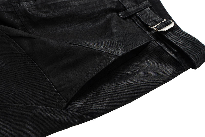 Close-up of black pants curved seam panel and belt strap detail