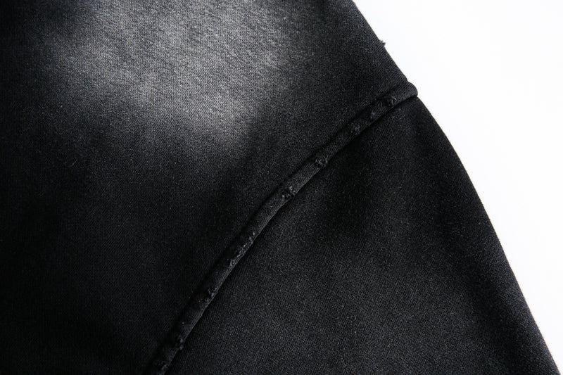 Close-up of washed black hoodie shoulder seam and fabric texture