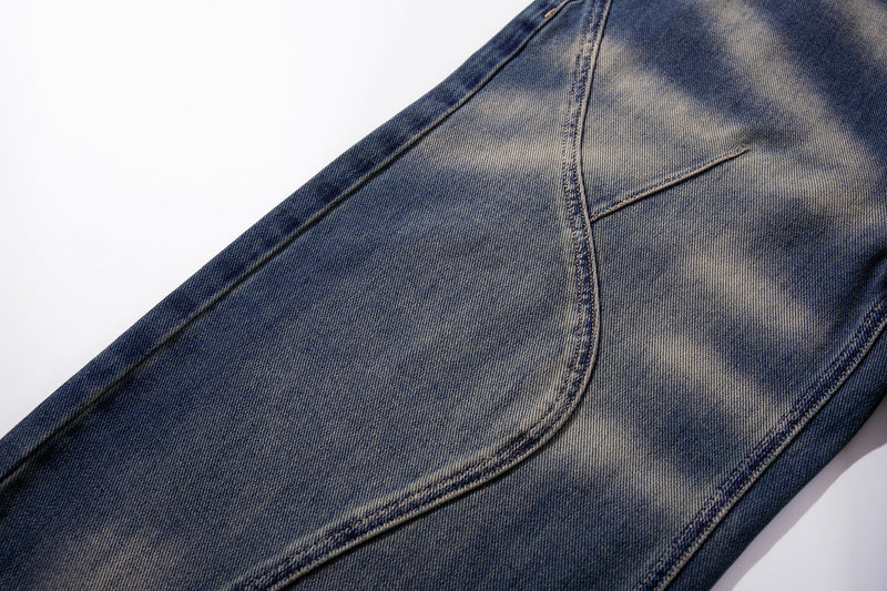 Close-up of curved panel seam on wide-leg jeans with smoke-fade blue denim wash