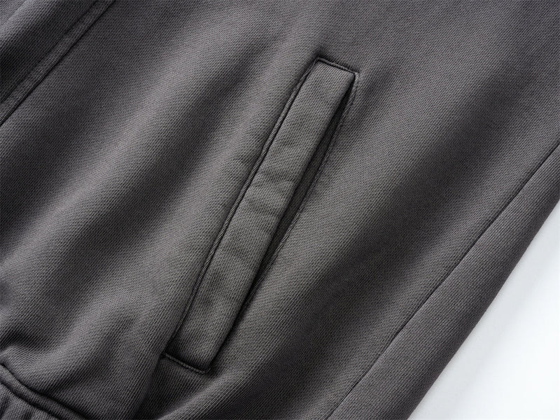 Close-up of black hoodie welt pocket on washed cotton fabric