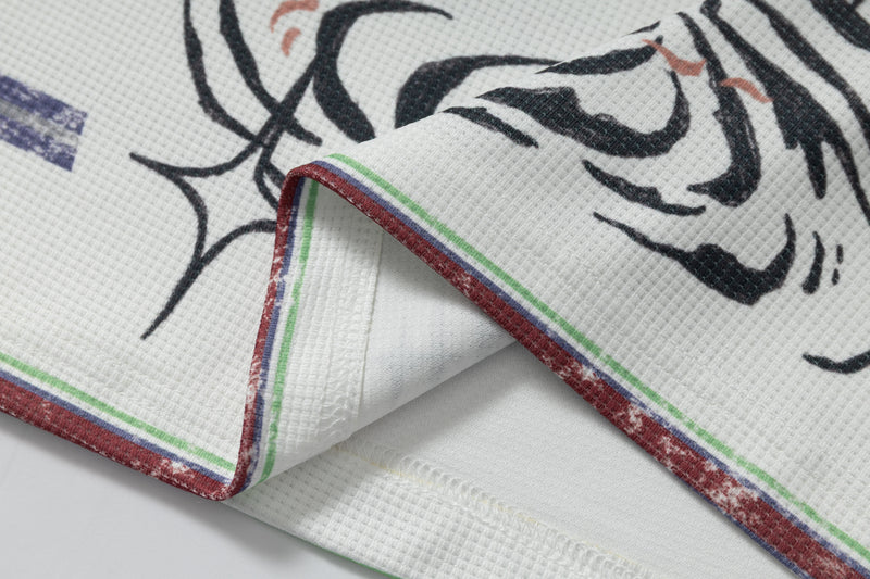 Close-up of shirt hem and abstract black graphic with multicolor trim