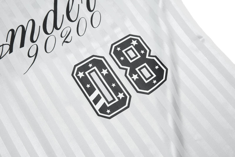 White striped football jersey with black script and large 06 graphic, featuring a retro streetwear design