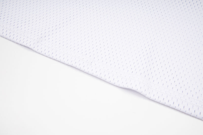 White mesh jersey fabric with perforated texture and clean hem detail on a minimalist background