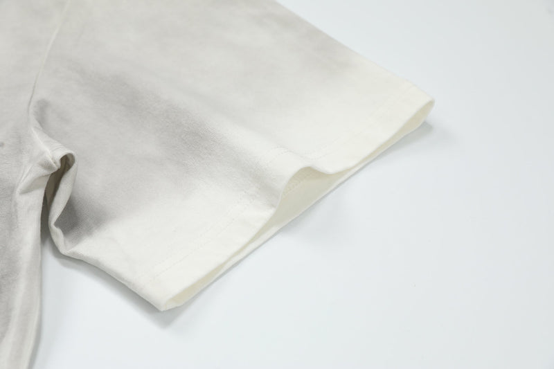 Cream oversized T-shirt sleeve detail with clean hem and soft cotton fabric on a white background