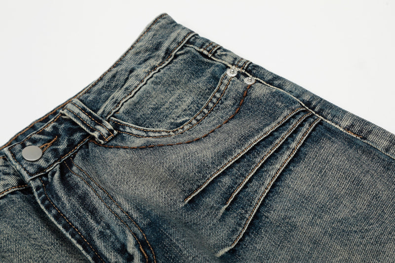 Close-up of the back yoke and pocket stitching on faded blue denim jeans