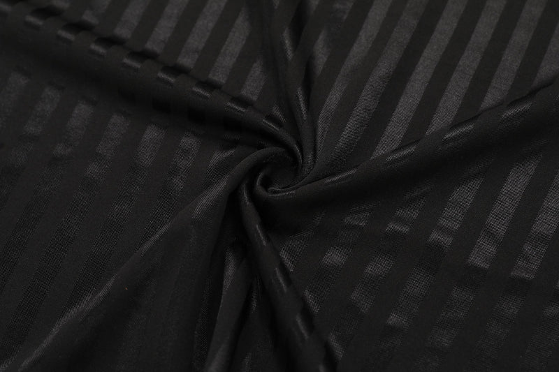 Close-up of black striped mesh soccer jersey fabric with a gathered twist texture