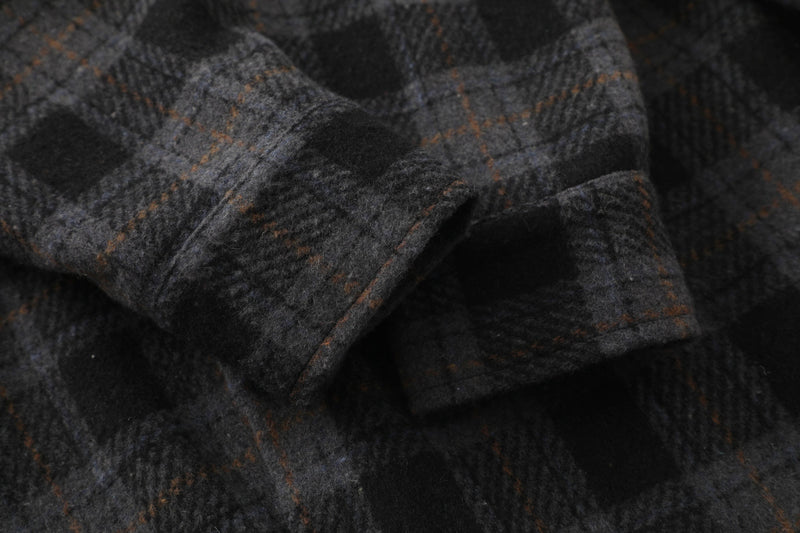 Close-up of dark plaid flannel fabric showing soft brushed weave and stitching
