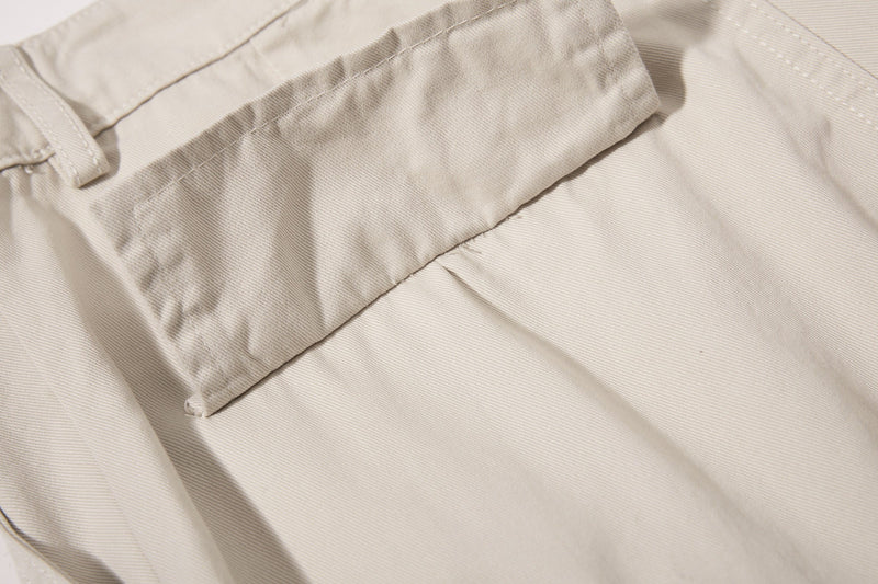 Close-up of beige cargo pocket flap with stitched edges