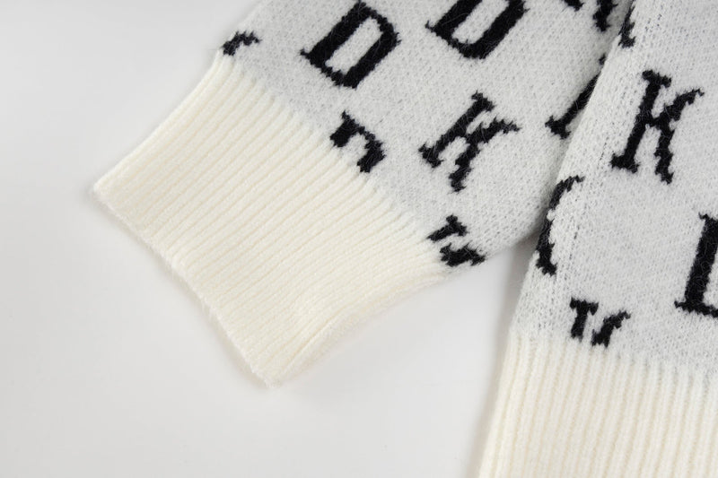 Close-up of white ribbed cuff on monogram knit hoodie sleeve