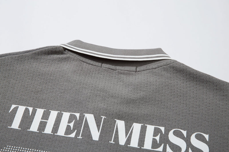 Close-up of gray polo collar and upper back with white striped trim and THEN MESS text