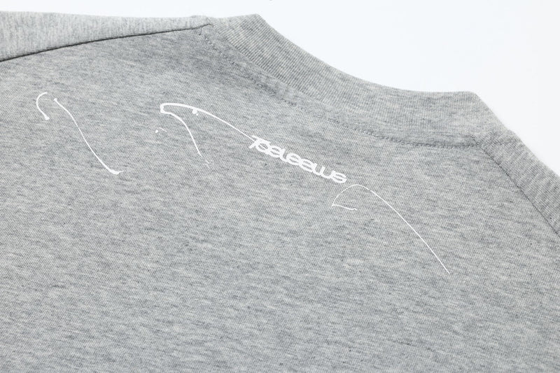 Close-up of light gray back shoulder with white graphic print on layered long sleeve tee