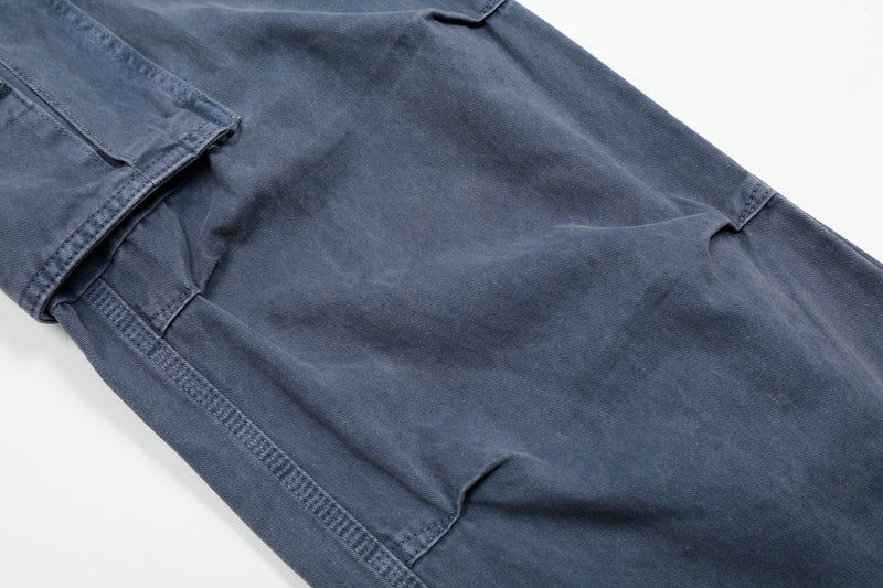 Close-up of washed blue cargo pants leg with side seam and flap cargo pocket