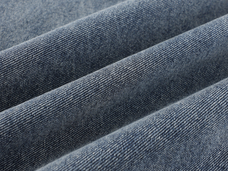 Close-up of faded blue denim twill texture and soft folds