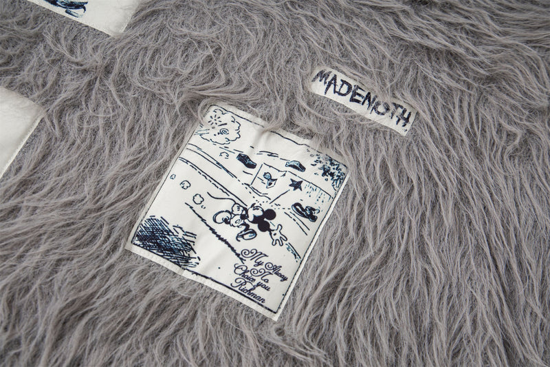 Close-up of gray sweater patch with Mickey Mouse-style graphic