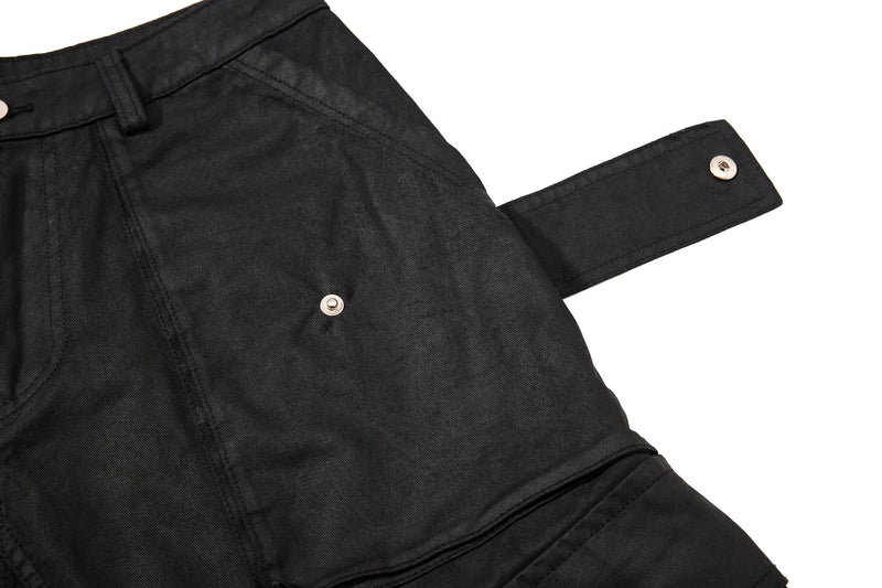 Close-up of black cargo shorts pocket with extended strap and snap closure
