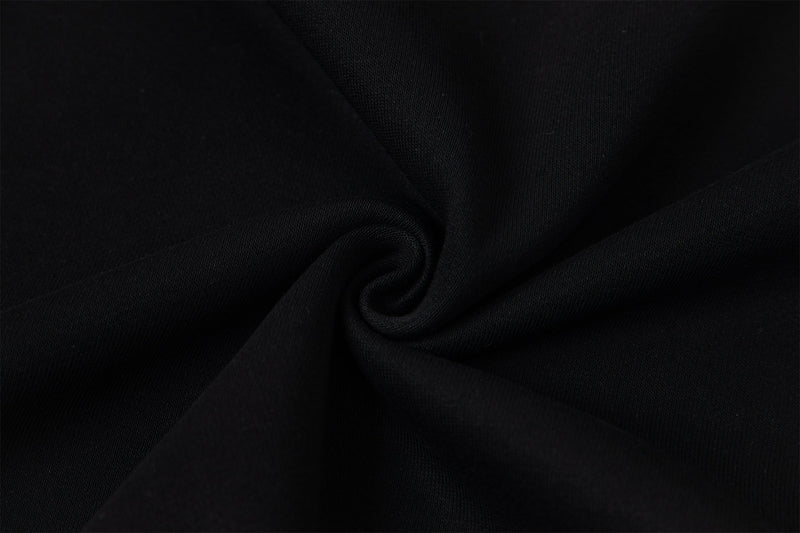 Close-up of black hoodie fabric folded in a swirl, showing smooth texture