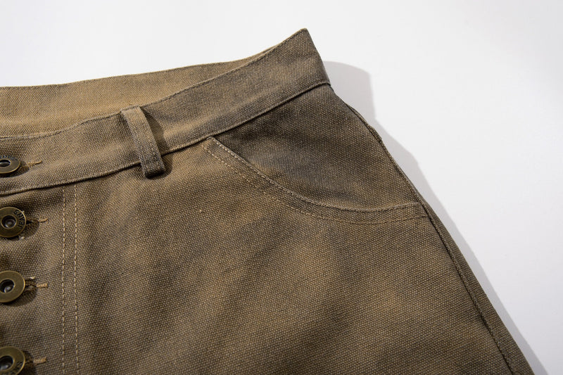 Close-up of front waistband and pocket edge on olive brown cargo shorts