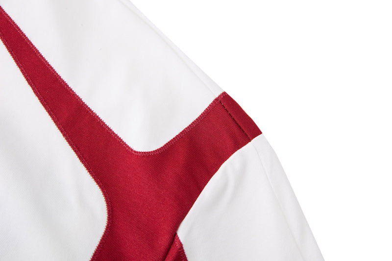 Close-up of a white retro football jersey with bold red V-shaped shoulder and sleeve trim