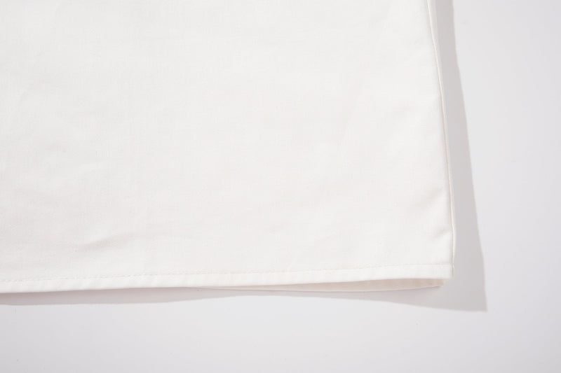Close-up of a white oversized graphic shirt hem with clean stitching and soft cotton texture