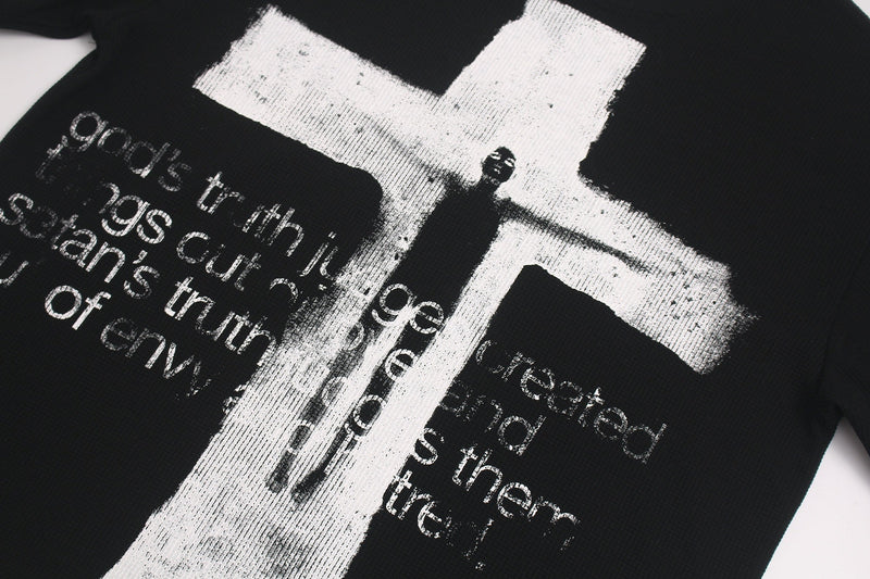 Black oversized tee with distressed white gothic cross and layered typography graphic on the front