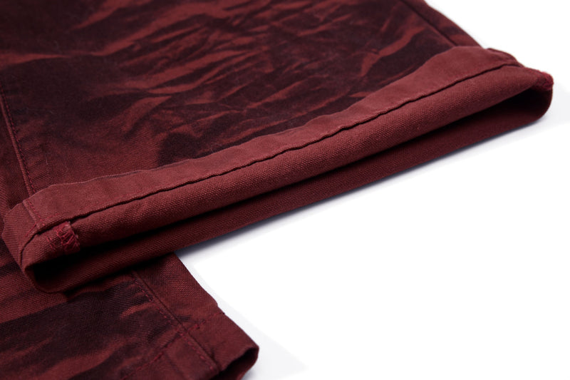 Close-up of the folded cuff on burgundy tiger-print pants