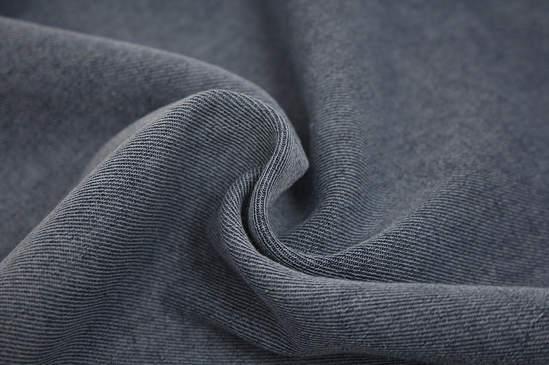 Close-up of soft vintage washed gray distressed T-shirt fabric with visible texture and folded drape