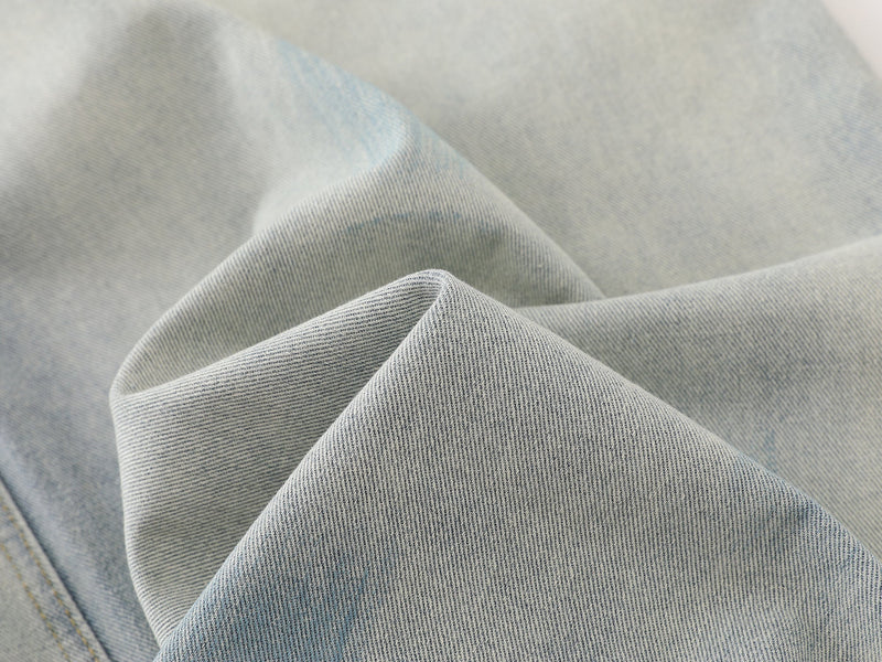 Close-up of light wash denim fabric texture with soft folds