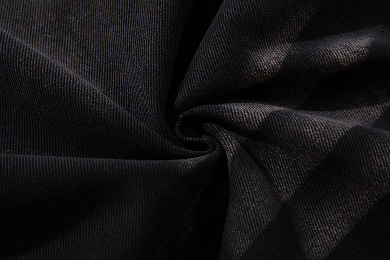 Close-up of dark denim fabric texture with soft folded drape
