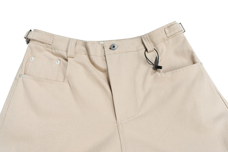 Beige cargo shorts waistband with buckle, snap button, and drawcord detail
