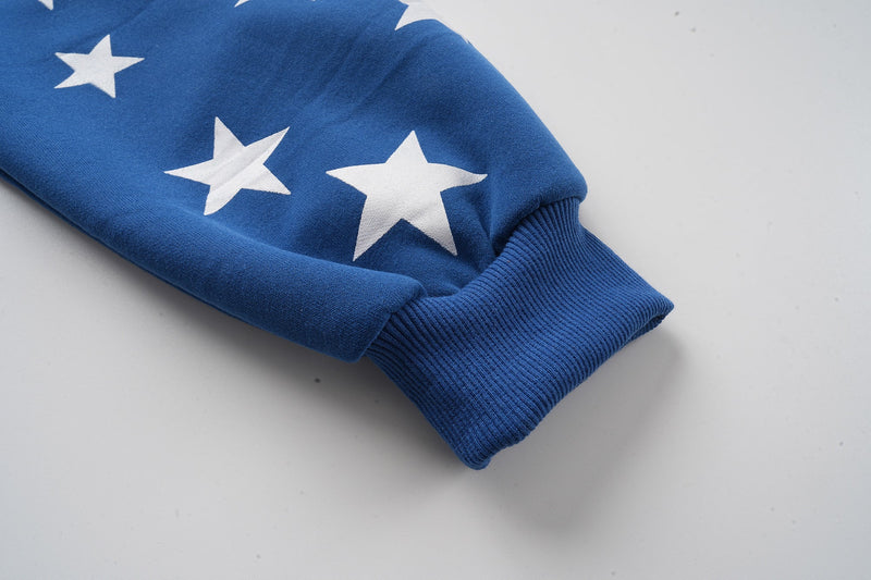 Close-up of blue hoodie sleeve cuff with white star print and ribbed wrist