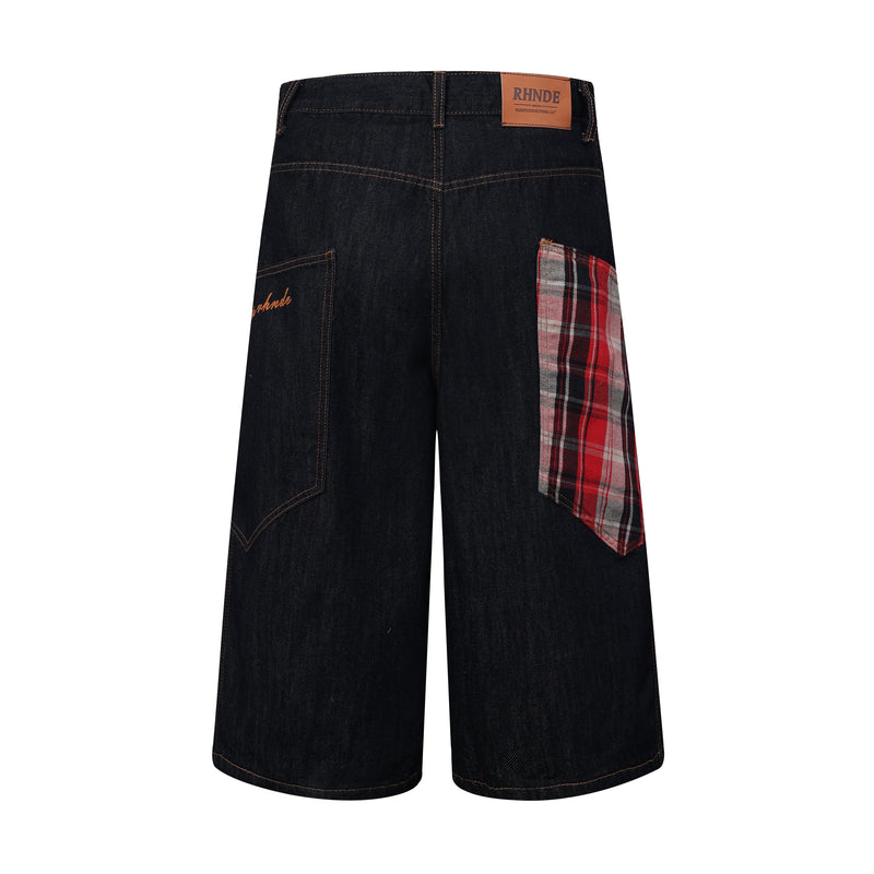 Back view of dark indigo denim jorts with red plaid side patch and logo label
