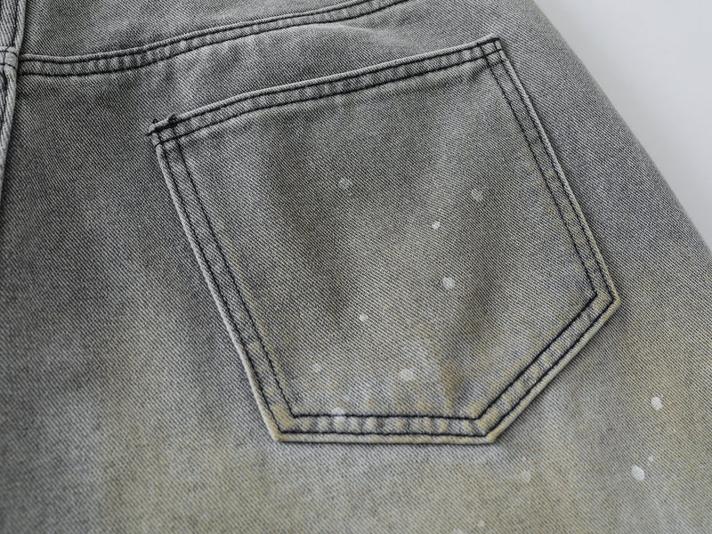 Close-up of back patch pocket on grey wash denim shorts with speckled fading