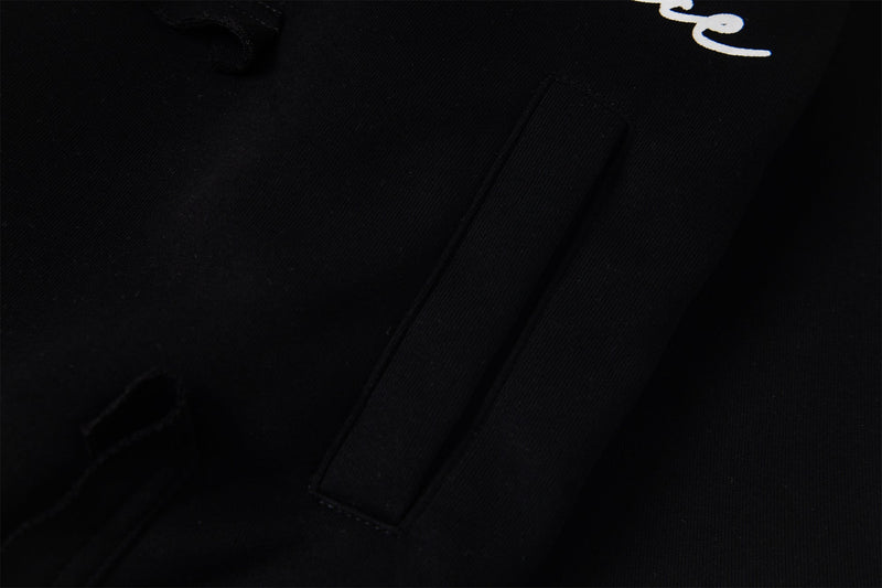Close-up of black hoodie body fabric with partial script graphic
