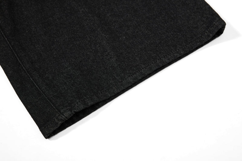 Close-up of a wide leg hem on black denim shorts