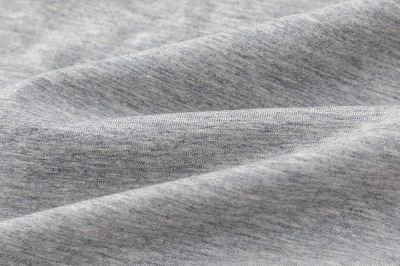Close-up of heather gray knit t-shirt fabric with soft folds and layered texture for a colorblock raglan look