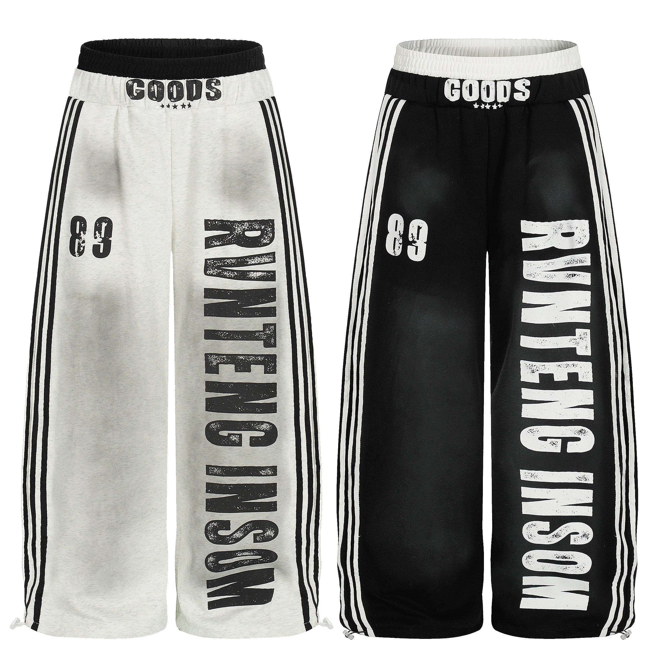 White and black oversized track pants with bold vertical lettering, triple side stripes, and contrast elastic waistband, show