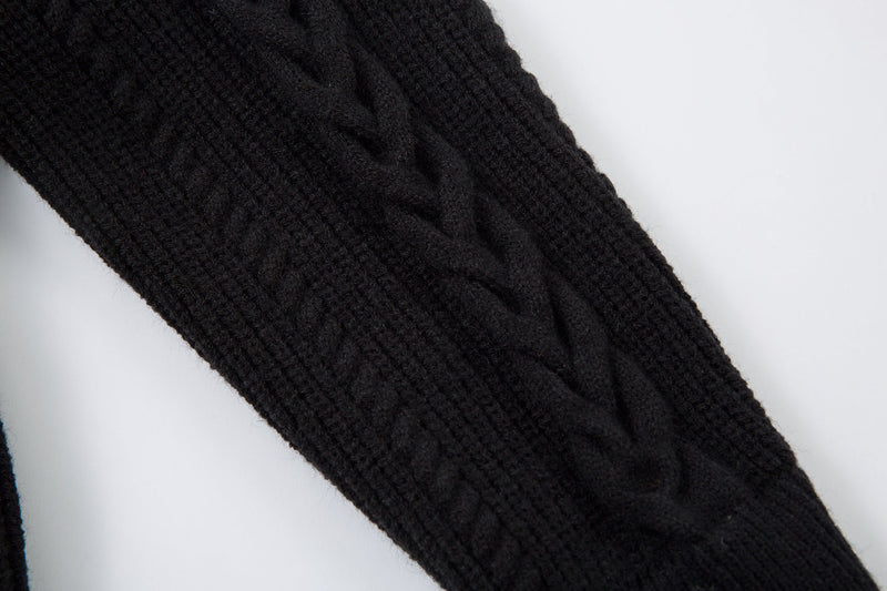 Close-up of black sweater sleeve with cable knit texture