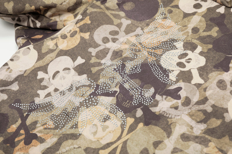 Close-up of rhinestone skull design on camouflage jacket front
