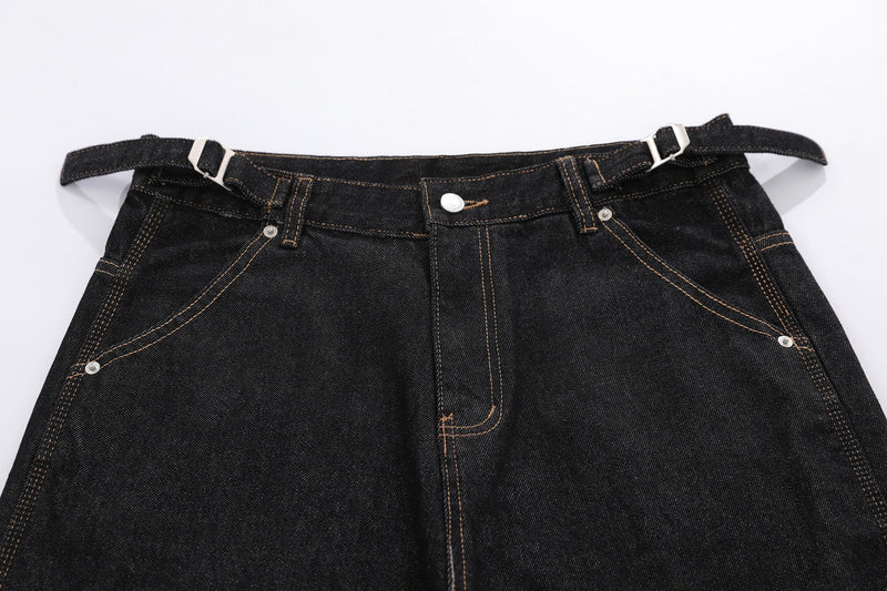 Close-up of black denim shorts front waistband and fly with belt straps across the top