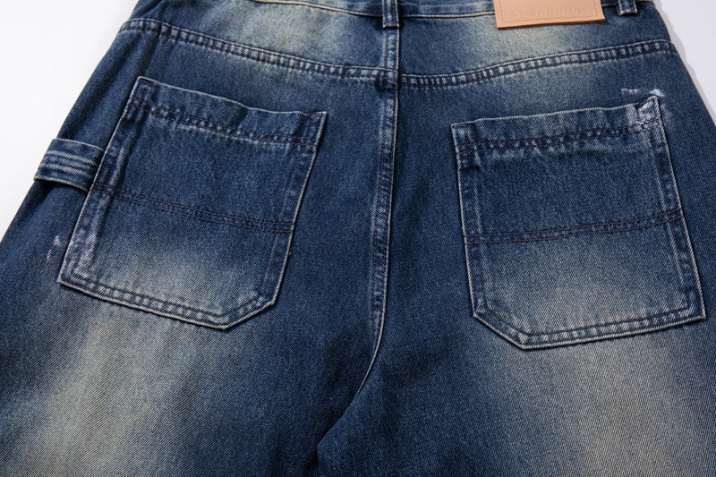 Close-up of back pockets on wide-leg jeans with faded wash and side cargo tab