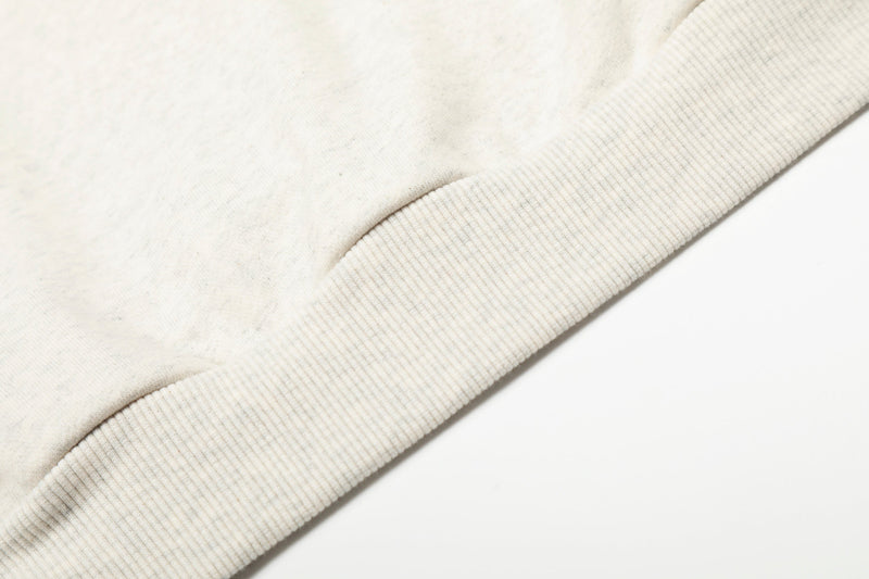 Close-up of cream hoodie cuff and hem ribbed knit texture
