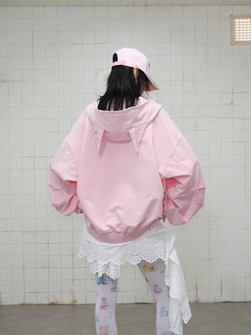 Back view of pink zip hoodie on model with oversized sleeves and ribbed hem