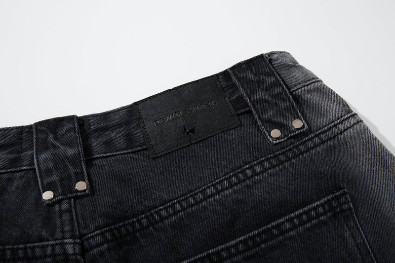 Close-up of the back waistband and brand patch on washed black denim