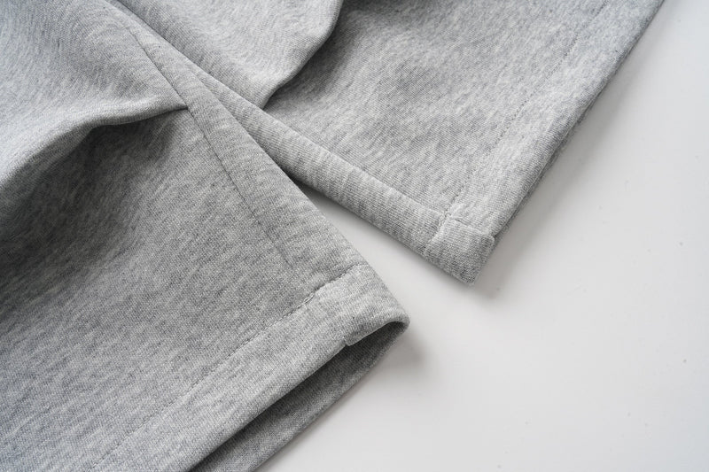 Close-up of gray sweat shorts cuffed leg openings and seam detailing