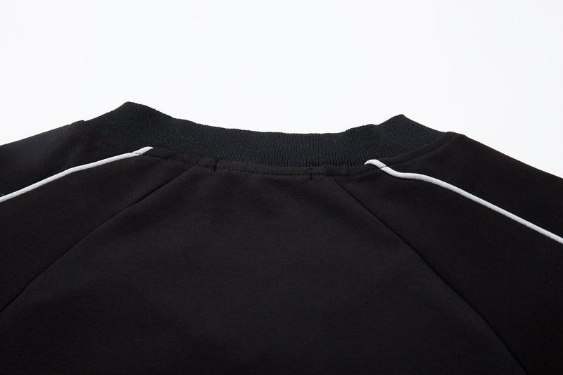 Black V-neck collar and shoulder seam detail on the raglan top