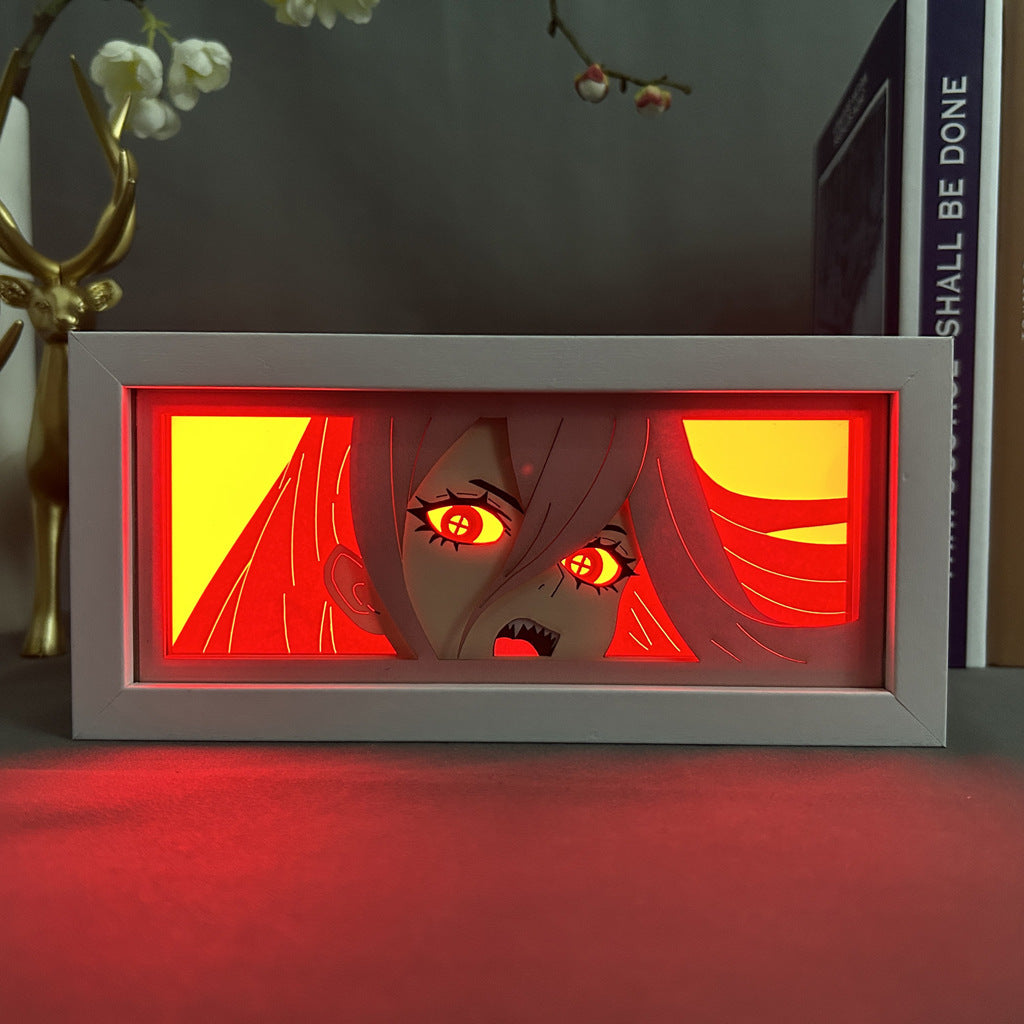 The Chainsaw Man Anime Light Box – Power 3D LED Lamp features a character with long hair and a surprised expression, enhanced by red hues and dynamic color-changing effects. Books and decor in the background add charm, reminiscent of an anime light box.