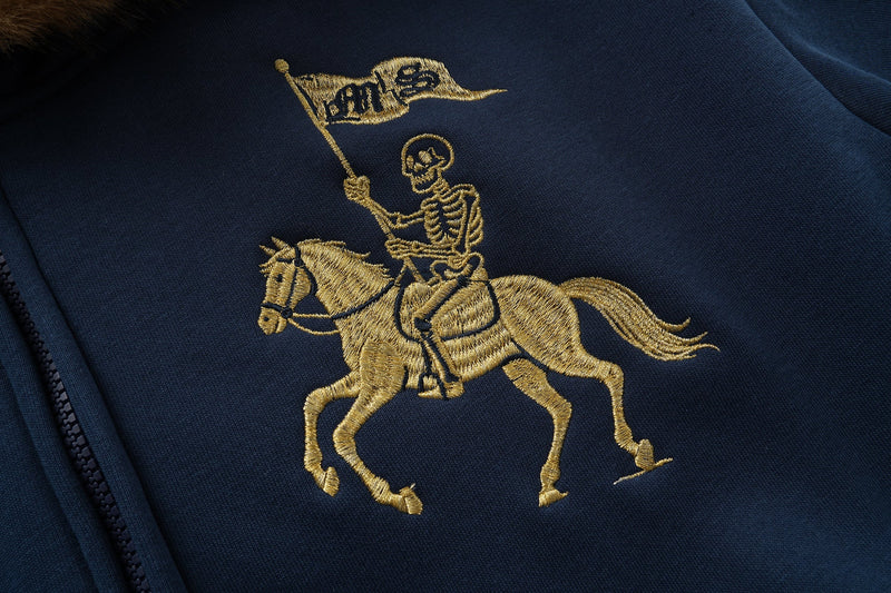 Close-up of gold horse rider embroidery on navy hoodie front