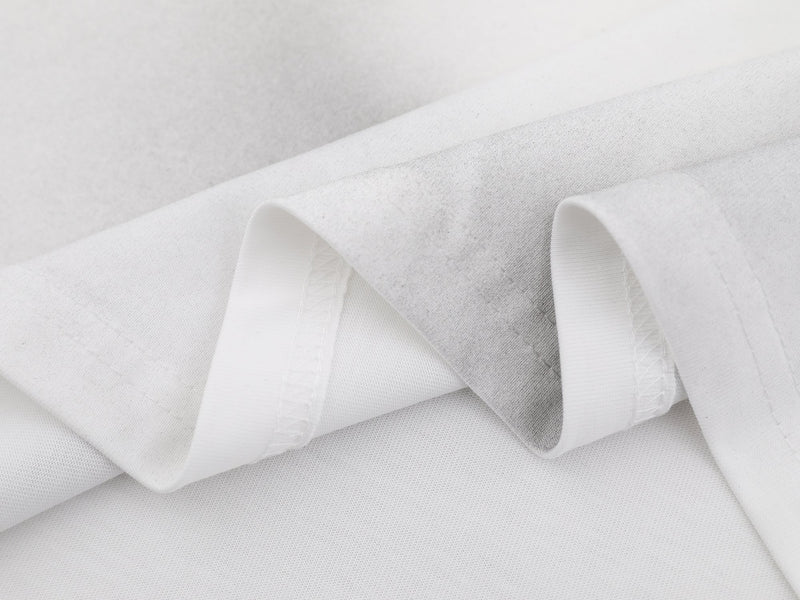 White washed cotton tee fabric with soft cloud-dye texture and visible folded seams for a streetwear look