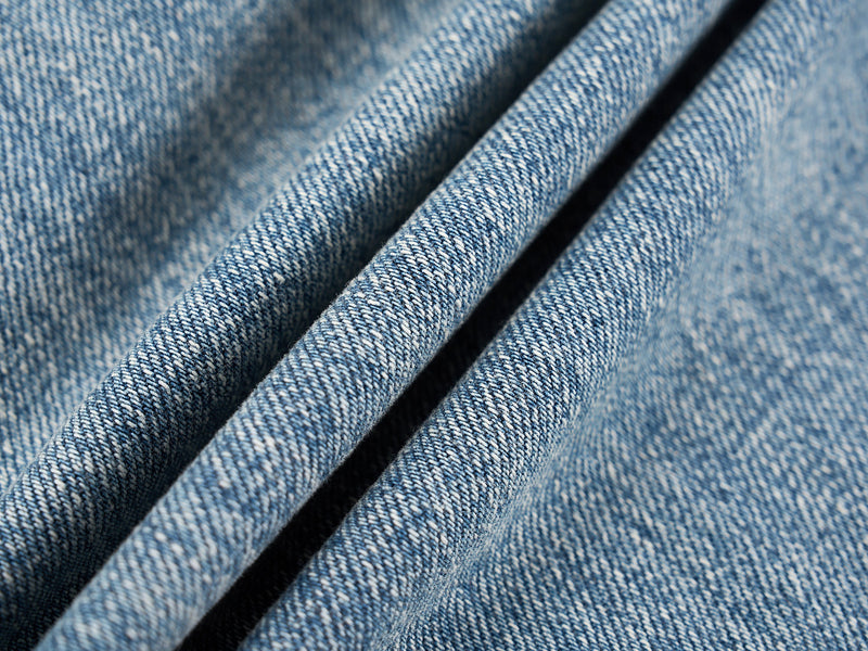 Close-up of blue denim fabric texture and folded seam
