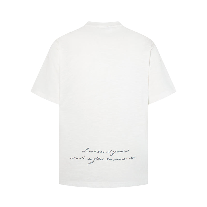 White oversized graphic tee with cursive prayer text printed near the lower back on a clean white background